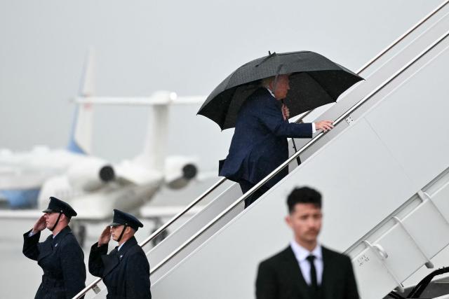 US President Donald Trump holds an umbrella as he boards Air Force One under the rain at Joint Base Andrews, Maryland on June 23, 2026. Trump is traveling to Macungie, Pennsylvania to speak at a Mack Trucks facility. (Photo by Mandel NGAN / AFP)