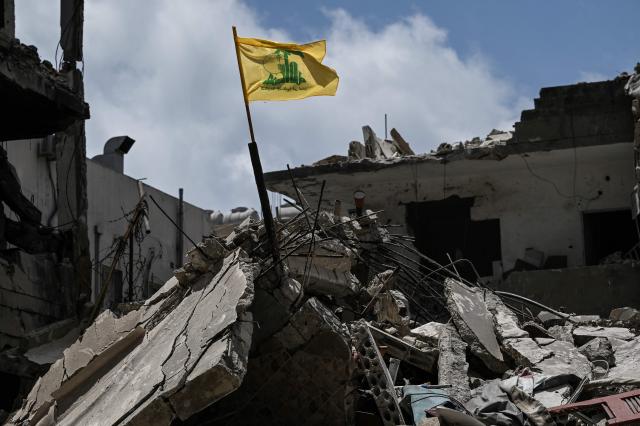 A yellow flag belonging to the Iran-backed Shia Muslim party Hezbollah flutters on top of the rubble of a building in the southern Lebanese coastal city of Tyre on June 23, 2026. Hezbollah chief on June 23, 2026, demanded a full, scheduled withdrawal of Israeli troops from Lebanon to make way for a Lebanese army deployment in the south following the US-Iran deal to end the Middle East war. (Photo by Joseph EID / AFP) / 