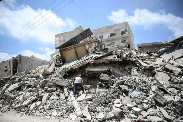 A man walks on the rubbles as he looks for items in a building hit in earlier Israeli military strikes on a neighbourhood in the southern Lebanese coastal city of Tyre on June 23, 2026. On June 22, 2026, mediators Pakistan and Qatar said that Tehran and Washington had agreed to set up a "de-confliction cell" to limit flare-ups in Lebanon following talks in Switzerland on ending the wider Middle East war, which Tehran has linked to halting the parallel conflict in Lebanon. (Photo by Joseph EID / AFP) / 