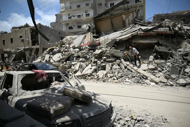A man walks on the rubbles as he looks for items in a building hit in earlier Israeli military strikes on a neighbourhood in the southern Lebanese coastal city of Tyre on June 23, 2026. On June 22, 2026, mediators Pakistan and Qatar said that Tehran and Washington had agreed to set up a "de-confliction cell" to limit flare-ups in Lebanon following talks in Switzerland on ending the wider Middle East war, which Tehran has linked to halting the parallel conflict in Lebanon. (Photo by Joseph EID / AFP) / 