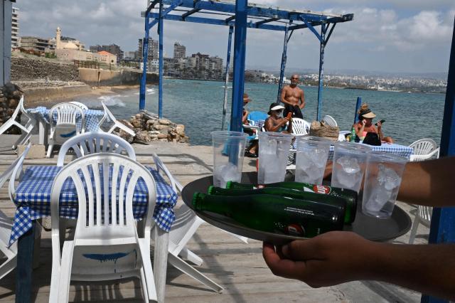 Residents sunbathe at a small beach cafe in the southern Lebanese coastal city of Tyre on June 23, 2026, days after the city saw numerous Israeli military strikes. On June 22, 2026, mediators Pakistan and Qatar said that Tehran and Washington had agreed to set up a "de-confliction cell" to limit flare-ups in Lebanon following talks in Switzerland on ending the wider Middle East war, which Tehran has linked to halting the parallel conflict in Lebanon. (Photo by Joseph EID / AFP) / 