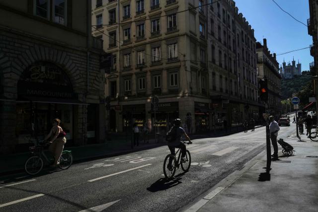 This photograph shows bikes and pedestrians in the Grenette street in Lyon on June 23, 2026. The Grenette street in central Lyon is testing the cohabitation between the ecologist city council and the Metropolis, which has just swung to the right. (Photo by OLIVIER CHASSIGNOLE / AFP)