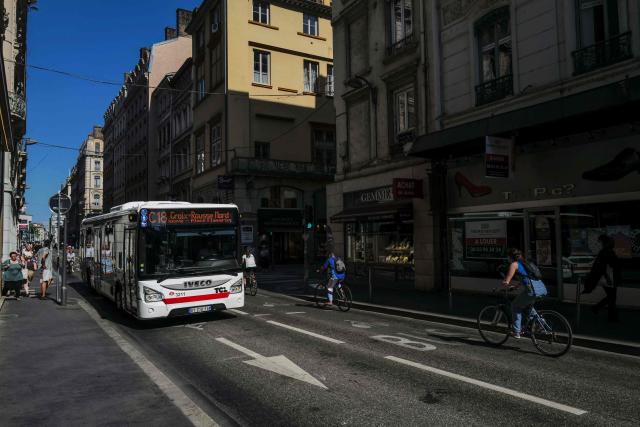 This photograph shows bus and bikes in the Grenette street in Lyon on June 23, 2026. The Grenette street in central Lyon is testing the cohabitation between the ecologist city council and the Metropolis, which has just swung to the right. (Photo by OLIVIER CHASSIGNOLE / AFP)