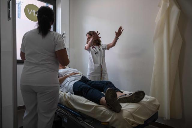 A doctor evaluates a patient suffering from heat exposure at Purpan Hospital as France experiences a heatwave, in Toulouse on June 23, 2026. France experienced its hottest day since measurements began on June 23, 2026 the national weather agency said. A deadly heatwave has battered France since last week, disrupting daily life and forcing the early closure of top Paris tourist hotspots. (Photo by Ed JONES / AFP)