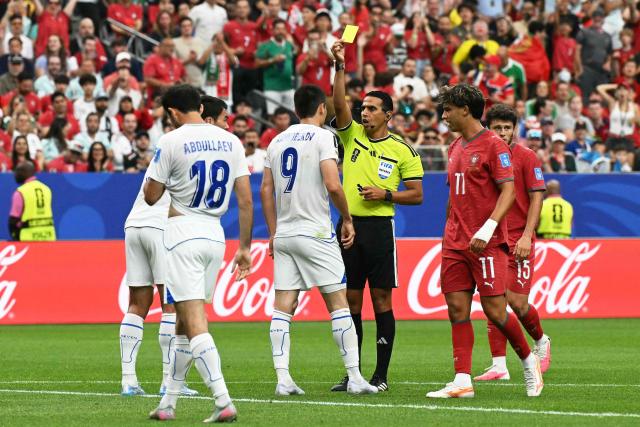 Moroccan referee Jalal Jayed (C) shows a yellow card Uzbekistan's forward #09 Odiljon Xamrobekov  during the 2026 World Cup Group K football match between Portugal and Uzbekistan at the Houston Stadium in Houston on June 23, 2026.  (Photo by RONALDO SCHEMIDT / AFP)