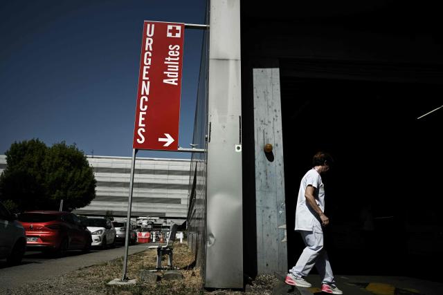 A healthcare worker enters the adult emergency department at the Pellegrin University Hospital during a heatwave in Bordeaux, south-western France on June 23, 2026. France on June 23, 2026 experienced its hottest day since measurements began in 1947, the national weather agency said. A deadly heatwave has battered France since last week, disrupting daily life and forcing the early closure of top Paris tourist hotspots. (Photo by Philippe LOPEZ / AFP)