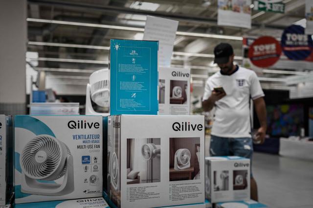 A man browses electric fans on display at a supermarket during a heatwave in Bordeaux, south-western France on June 23, 2026. France on June 23, 2026 experienced its hottest day since measurements began in 1947, the national weather agency said. A deadly heatwave has battered France since last week, disrupting daily life and forcing the early closure of top Paris tourist hotspots. (Photo by Philippe LOPEZ / AFP)