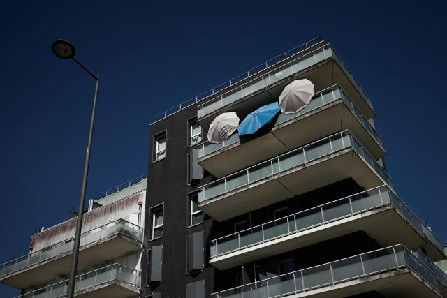 Opened umbrellas are displayed on a balcony of a residential building as residents improvised shade against extreme temperatures during a heatwave in Bordeaux, south-western France on June 23, 2026. France on June 23, 2026 experienced its hottest day since measurements began in 1947, the national weather agency said. A deadly heatwave has battered France since last week, disrupting daily life and forcing the early closure of top Paris tourist hotspots. (Photo by Philippe LOPEZ / AFP)