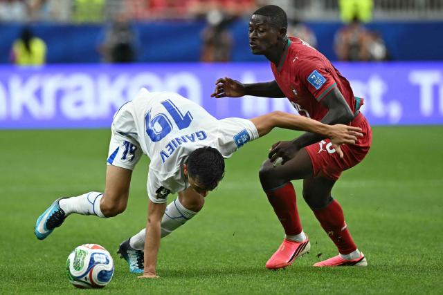Uzbekistan's midfielder #19 Azizjon Ganiev (L) fights for the ball with Portugal's defender #25 Nuno Mendes (R) during the 2026 World Cup Group K football match between Portugal and Uzbekistan at the Houston Stadium in Houston on June 23, 2026.  (Photo by Paul ELLIS / AFP)