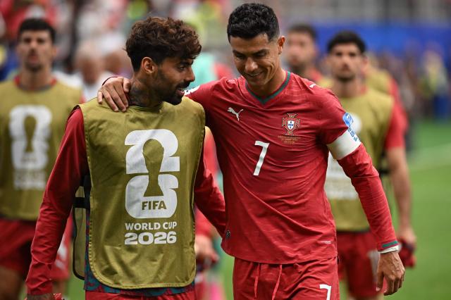 Portugal's midfielder #24 Samu Costa (L) speaks with Portugal's forward #07 Cristiano Ronaldo at half-time of the 2026 World Cup Group K football match between Portugal and Uzbekistan at the Houston Stadium in Houston on June 23, 2026.  (Photo by Paul ELLIS / AFP)