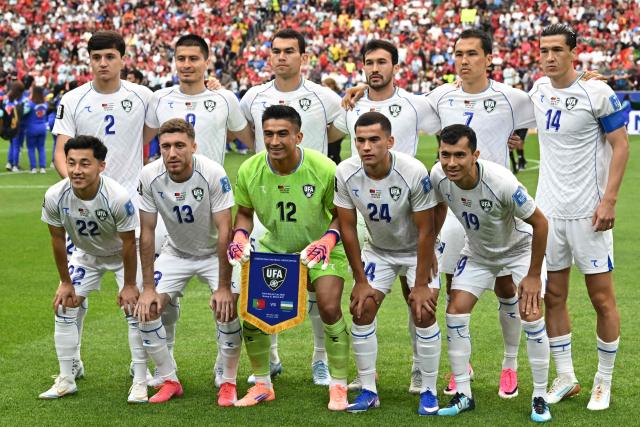 (From L) Uzbekistan's midfielder #22 Abbosbek Fayzullaev, Manchester City's Uzbek defender #45 Abdukodir Khusanov, Uzbekistan's defender #13 Sherzod Nasrullaev, Uzbekistan's forward #09 Odiljon Xamrobekov, Uzbekistan's goalkeeper #12 Abduvohid Nematov, Uzbekistan's defender #05 Rustam Ashurmatov, Uzbekistan's defender #24 Behruzjon Karimov, Uzbekistan's defender #18 Abdulla Abdullaev, Uzbekistan's midfielder #19 Azizjon Ganiev, Uzbekistan's midfielder #07 Otabek Shukurov and Uzbekistan's forward #14 Eldor Shomurodov pose ahead of the 2026 World Cup Group K football match between Portugal and Uzbekistan at the Houston Stadium in Houston on June 23, 2026.  (Photo by Paul ELLIS / AFP)