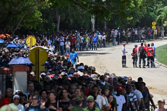 People line up in front of the Ministry of the Revolutionary Armed Forces to pay tribute to Commander Ramiro Valdés during his funeral in Havana on June 23, 2026. Ramiro Valdes Menendez, a close associate of brothers Fidel and Raul Castro and founder of the Cuban intelligence services, has died at the age of 94, Cuban President Miguel Diaz-Canel announced on June 21, 2026. (Photo by YAMIL LAGE / AFP)