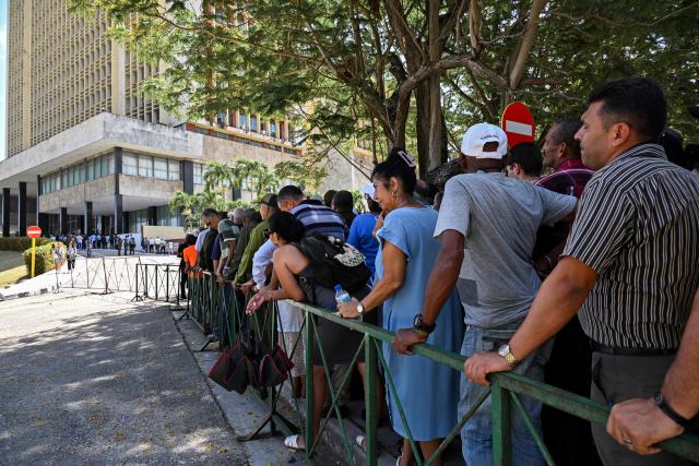 People line up in front of the Ministry of the Revolutionary Armed Forces to pay tribute to Commander Ramiro Valdés during his funeral in Havana on June 23, 2026. Ramiro Valdes Menendez, a close associate of brothers Fidel and Raul Castro and founder of the Cuban intelligence services, has died at the age of 94, Cuban President Miguel Diaz-Canel announced on June 21, 2026. (Photo by YAMIL LAGE / AFP)