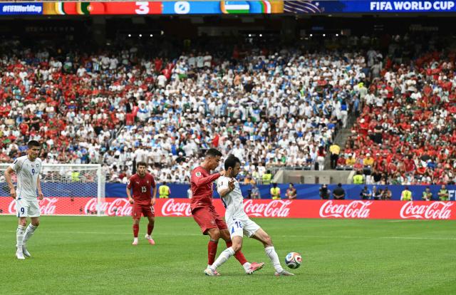 Portugal's forward #07 Cristiano Ronaldo (L) fights for the ball with Uzbekistan's defender #18 Abdulla Abdullaev  during the 2026 World Cup Group K football match between Portugal and Uzbekistan at the Houston Stadium in Houston on June 23, 2026.  (Photo by RONALDO SCHEMIDT / AFP)
