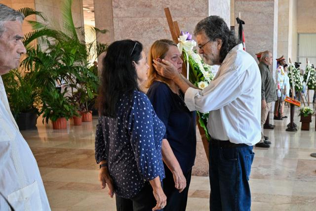Abel Prieto (R), Cuba's presidential advisor on culture, comforts Alicia Alonso Becerra, the widow of Commander Ramiro Valdes, during his wake at the Ministry of the Revolutionary Armed Forces in Havana, June 23, 2026. Ramiro Valdes Menendez, a close associate of brothers Fidel and Raul Castro and founder of the Cuban intelligence services, has died at the age of 94, Cuban President Miguel Diaz-Canel announced on June 21, 2026. (Photo by Pablo PORCIUNCULA / AFP)