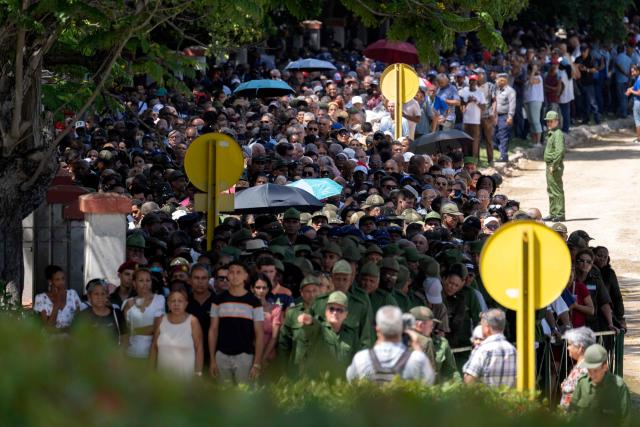 People line up in front of the Ministry of the Revolutionary Armed Forces to pay tribute to Commander Ramiro Valdés during his funeral in Havana on June 23, 2026. Ramiro Valdes Menendez, a close associate of brothers Fidel and Raul Castro and founder of the Cuban intelligence services, has died at the age of 94, Cuban President Miguel Diaz-Canel announced on June 21, 2026. (Photo by Pablo PORCIUNCULA / AFP)