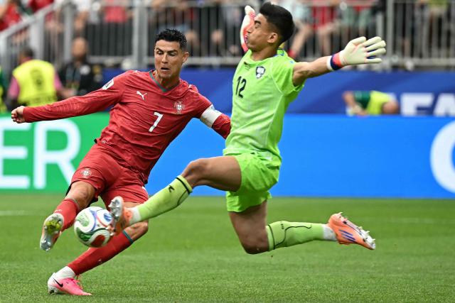 TOPSHOT - Portugal's forward #07 Cristiano Ronaldo (L) attempts to score in front of Uzbekistan's goalkeeper #12 Abduvohid Nematov during the 2026 World Cup Group K football match between Portugal and Uzbekistan at the Houston Stadium in Houston on June 23, 2026.  (Photo by Paul ELLIS / AFP)