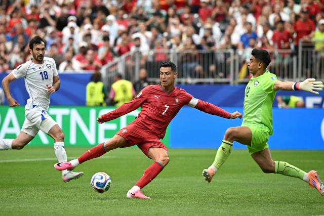 Portugal's forward #07 Cristiano Ronaldo (L) attempts to score in front of Uzbekistan's goalkeeper #12 Abduvohid Nematov during the 2026 World Cup Group K football match between Portugal and Uzbekistan at the Houston Stadium in Houston on June 23, 2026.  (Photo by Paul ELLIS / AFP)