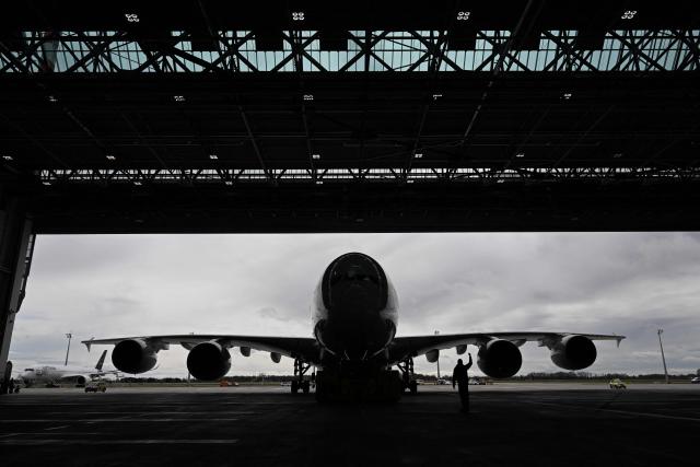 (FILES) An Airbus A380-800 of German airline Lufthansa arrives inside a hangar after its arrival at Munich International Airport, Munich, southern Germany, on April 12, 2023. The European Union Aviation Safety Agency (EASA) has ordered inspections of 16 Airbus A380 aircraft, including five on an urgent basis, after cracks were discovered in the wing structure of one plane, the aircraft manufacturer Airbus confirmed on June 23, 2026. (Photo by CHRISTOF STACHE / AFP)