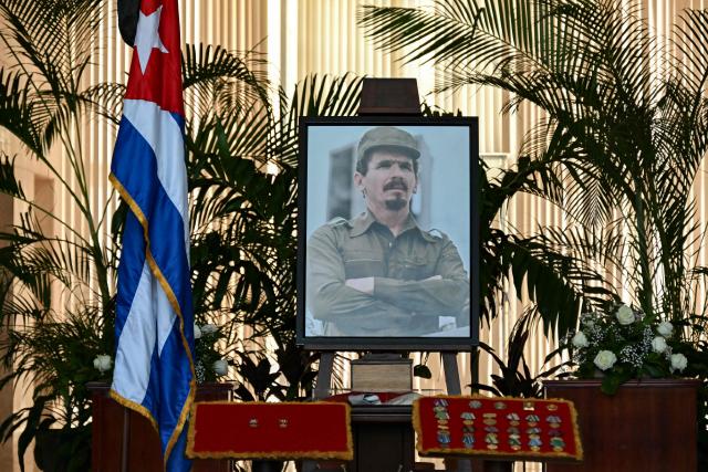 View of the portrait of Commander Ramiro Valdes next to a Cuban national flag during his funeral at the Ministry of the Revolutionary Armed Forces in Havana, on June 23, 2026. Ramiro Valdes Menendez, a close associate of brothers Fidel and Raul Castro and founder of the Cuban intelligence services, has died at the age of 94, Cuban President Miguel Diaz-Canel announced on June 21, 2026. (Photo by YAMIL LAGE / AFP)