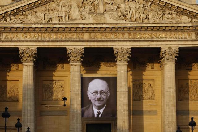 A portrait of the late historian and resistance fighter Marc Bloch adorns the facade of the Pantheon before his induction ceremony along with his wife Simonne Vidal, in Paris on June 23, 2026. Historian Marc Bloch, a soldier and Resistance fighter murdered by the Gestapo, will be inducted into Frances Panthéon on June 23 in a tribute to the author of "Strange Defeat", a major work tahat President Emmanuel Macron has described as a warning against the "conformism" that undermines the "French will."
The ceremony marks the sixth Panthéon induction of Macron's two terms, following those of Simone Veil, writer Maurice Genevoix, Josephine Baker, Resistance fighter Missak Manouchian and Robert Badinter. (Photo by Yoan VALAT / POOL / AFP)