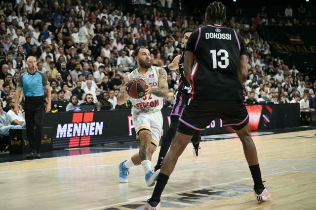 AS Monaco's US guard #32 Mike James (L) fights for the ball with Paris Basketball's French-Central African forward #13 Allan Dokossi during the French Ligue Nationale de Basket (LNB Elite) Pro A match 5 of the final between Paris Basketball and AS Monaco Basket, at the Adidas Arena in Paris on June 23, 2026. James is wearing the number 32, which is usually worn by his teammate Matthew Strazel, who is absent for this decisive match after being handed a one-match ban (plus a suspended one) on June 22, 2026 by the National Basketball League (LNB) disciplinary committee. (Photo by JULIEN DE ROSA / AFP)
