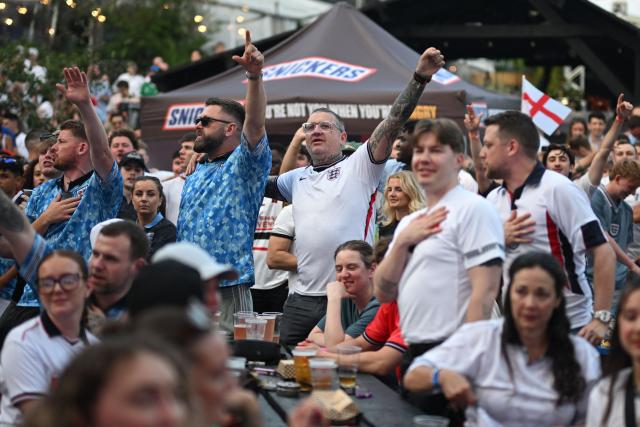 England supporters react to the national anthem being played ahead of watching the 2026 World Cup Group L football match between England and Ghana, at the 4TheFans Fan Park in Manchester, north-west England on June 23, 2026. (Photo by Oli SCARFF / AFP)
