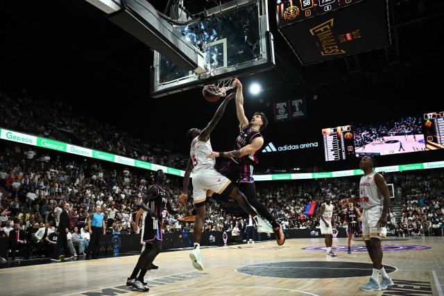 Paris Basketball's US forward #34 Daulton Hommes (CR) dunks the ball during the French Ligue Nationale de Basket (LNB Elite) Pro A match 5 of the final between Paris Basketball and AS Monaco Basket, at the Adidas Arena in Paris on June 23, 2026. (Photo by JULIEN DE ROSA / AFP)