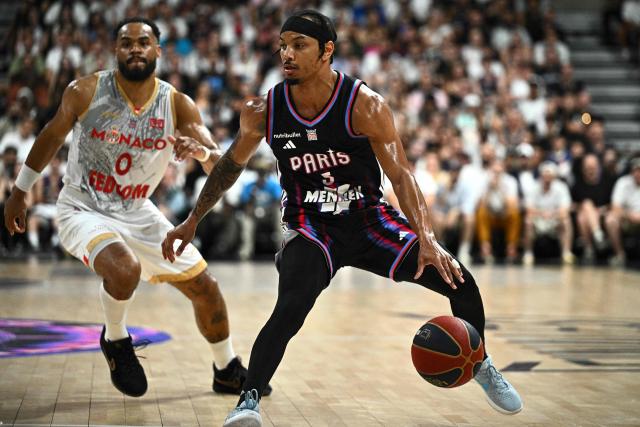 Paris Basketball's US point guard #05 Justin Robinson (C) dribbles the ball during the French Ligue Nationale de Basket (LNB Elite) Pro A match 5 of the final between Paris Basketball and AS Monaco Basket, at the Adidas Arena in Paris on June 23, 2026. (Photo by JULIEN DE ROSA / AFP)