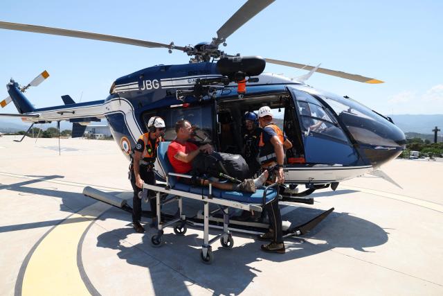 Members of Ajaccio's High Mountain Gendarmerie Platoon (PGHM, Peleton de Gendarmerie de Haute Montagne), an elite unit of the French Gendarmerie specialising in mountain rescue and law enforcement in high-altitude and alpine environments, evacuate an injured tourist on the GR20 hiking trail at the Hospital in Ajaccio on the French Mediterranean island of Corsica on June 23, 2026. (Photo by Pascal POCHARD-CASABIANCA / AFP)