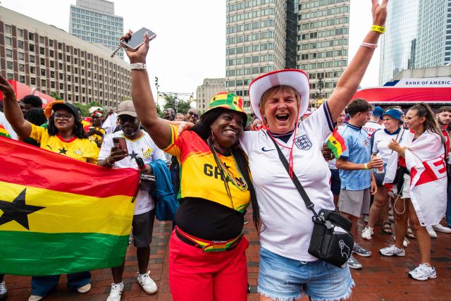 An England fan and a Ghana fan dance together during the FIFA Fan Festival watch party for the 2026 FIFA World Cup match between England and Ghana in Boston, Massachusetts, on June 23, 2026. (Photo by JOSEPH PREZIOSO / AFP)