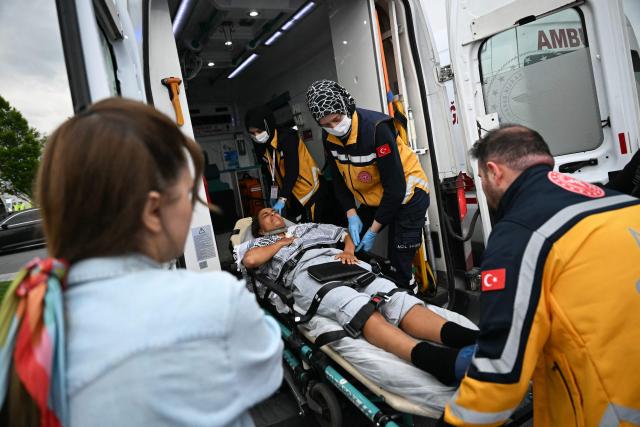 (FILES) A member of the Global Sumud Flotilla headed for Gaza and arrested and deported by Israel is loaded into an ambulance on a stretcher following the group's arrival at Istanbul Airport on May 21, 2026. International condemnation has mounted since May 2026 regarding the treatment of these 430 activists, including around 30 French nationals. France and Italy have launched judicial investigations into allegations of torture and war crimes, which will seek to establish who is responsible, whilst Australia has announced an independent inquiry. The Israeli authorities have rejected these accusations. (Photo by Ozan KOSE / AFP)