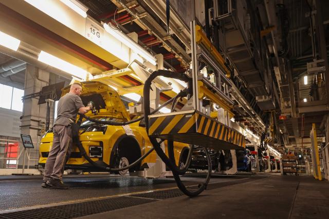 (FILES) An employee works on an assembly line at the Ampere ElectriCity Renault Group manufacture site in Douai on March 5, 2025. Workers in the automotive sector are suffocating in the face of the very high temperatures that are driving up the mercury in factories, where production is not slowing down. The Nord department, which will go on red heatwave alert on June 24 at noon, is expected to experience an incandescent end of the week, with temperatures of up to 39 degrees locally according to Météo-France. (Photo by FRANCOIS LO PRESTI / AFP)