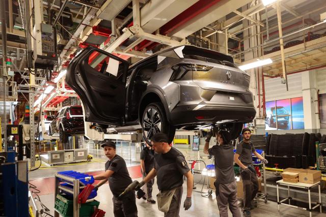 (FILES) Employees work on an assembly line at the Ampere ElectriCity Renault Group manufacture site in Douai on March 5, 2025. Workers in the automotive sector are suffocating in the face of the very high temperatures that are driving up the mercury in factories, where production is not slowing down. The Nord department, which will go on red heatwave alert on June 24 at noon, is expected to experience an incandescent end of the week, with temperatures of up to 39 degrees locally according to Météo-France. (Photo by FRANCOIS LO PRESTI / AFP)