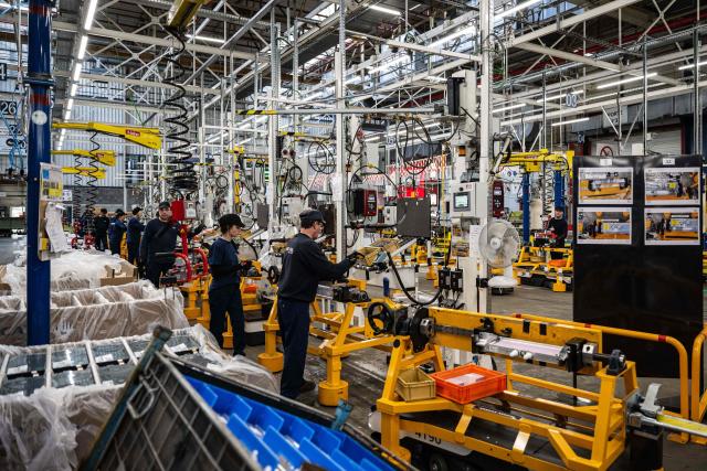(FILES) Operators work at the battery workshop of the Stellantis cars factory in Hordain, northern France on October 27, 2022. Workers in the automotive sector are suffocating in the face of the very high temperatures that are driving up the mercury in factories, where production is not slowing down. The Nord department, which will go on red heatwave alert on June 24 at noon, is expected to experience an incandescent end of the week, with temperatures of up to 39 degrees locally according to Météo-France. (Photo by Sameer Al-DOUMY / AFP)