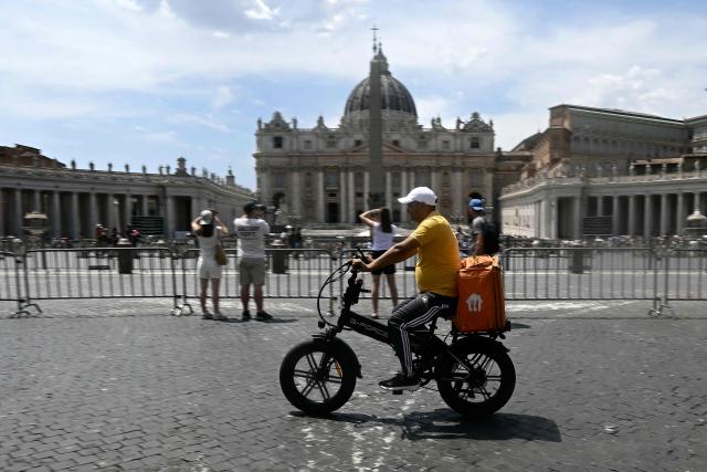 A food delivery firm Just Eat's rider cycles near the Vatican during a heatwave, in Rome on June 24, 2026. The Lazio region where Rome is located has approved an order for construction workers and delivery riders not to work between 12:30 pm and 4:00 pm due to the high temperatures. But the order is widely flouted and food delivery apps do not notify their customers of any restrictions around those hours.  (Photo by Filippo MONTEFORTE / AFP)