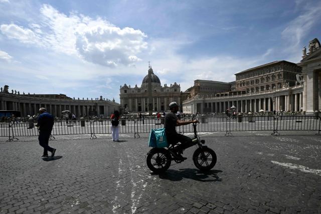 A food delivery firm Deliveroo's rider cycles near the Vatican during a heatwave, on June 24, 2026. The Lazio region where Rome is located has approved an order for construction workers and delivery riders not to work between 12:30 pm and 4:00 pm due to the high temperatures. But the order is widely flouted and food delivery apps do not notify their customers of any restrictions around those hours.  (Photo by Filippo MONTEFORTE / AFP)