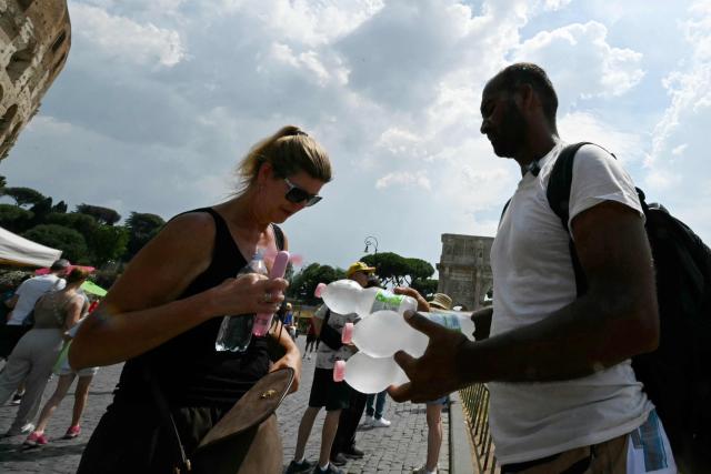 A man sells fresh water bottles to tourists near the Colosseum in Rome on June 24, 2026. (Photo by Andreas SOLARO / AFP)