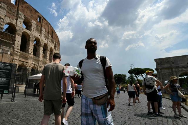 A man sells fresh water bottles to tourists near the Colosseum in Rome on June 24, 2026. (Photo by Andreas SOLARO / AFP)