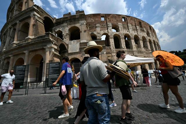 A street vendor sells hats to tourists near the Colosseum in Rome on June 24, 2026 (Photo by Andreas SOLARO / AFP)