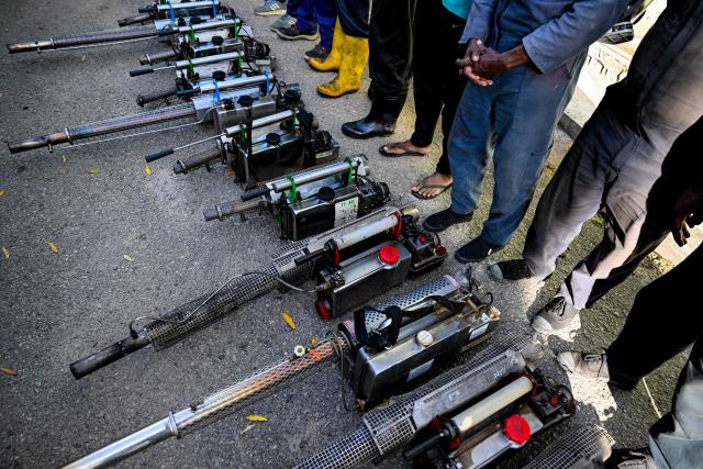 Municipal workers gather with mosquito fogging machines before fumigating a residential area during a nationwide dengue control campaign in Colombo on June 24, 2026. (Photo by Ishara S. KODIKARA / AFP)