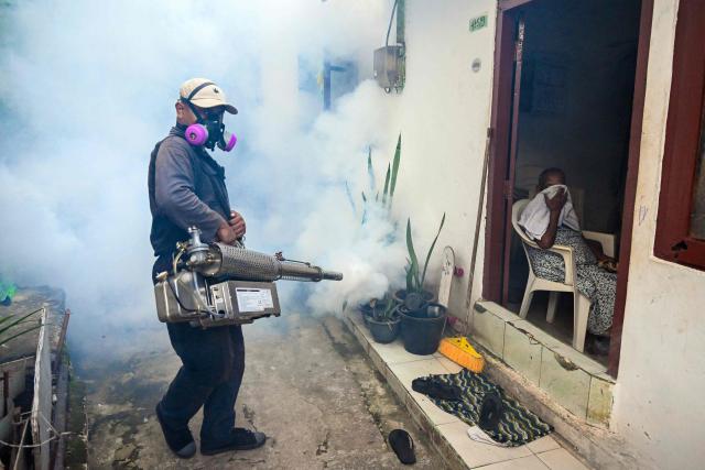 A municipal worker fumigates a residential area during a nationwide dengue prevention campaign in Colombo on June 24, 2026. (Photo by Ishara S. KODIKARA / AFP)