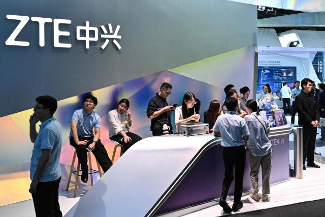People visit the ZTE booth during the Mobile World Congress (MWC) in Shanghai on June 24, 2026. (Photo by HECTOR RETAMAL / AFP)