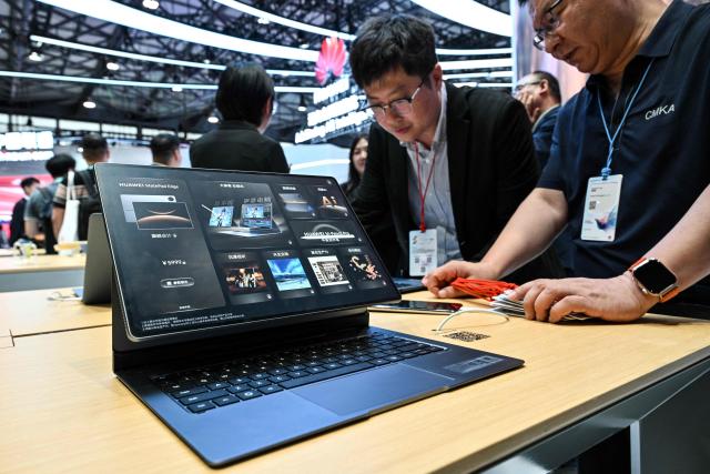 People visit the Huawei booth during the Mobile World Congress (MWC) in Shanghai on June 24, 2026. (Photo by HECTOR RETAMAL / AFP)