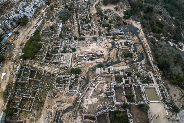 (FILES) This aerial view shows water flowing through the ruins at the site of the ancient Greco-Roman city of Cyrene (Shahat) in eastern Libya, about 60 kilometres (37 miles) west of Derna, on September 21, 2023, in the aftermath of a devastating flood. In eastern Libya's ancient ruins of Cyrene and Apollonia -- targeted by jihadist groups and later ravaged by Storm Daniel -- a small group of passionate archaeologists have taken it upon themselves to safeguard the sites. The UNESCO-listed ruins were once the heart of a unique network of Greek colonies in North Africa. (Photo by Ozan KOSE / AFP)