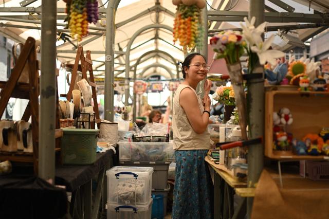 A stallholder uses a portable fan to cool off as they work in York Market during a heatwave, in York, on June 24, 2026. The UK's meteorological office has issued an extremely rare red heat warning -- only issued once before -- for June24 and 25, as temperatures could soar to 40C, unprecedented for the time of the year. (Photo by Oli SCARFF / AFP)