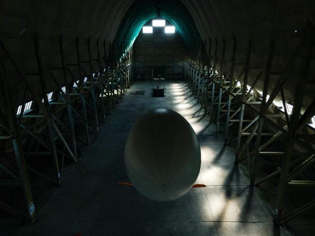 This aerial photograph taken on June 24, 2026 shows an individual airship flying at the Ecausseville's airship hangar, in Ecausseville, western France. (Photo by Lou BENOIST / AFP)