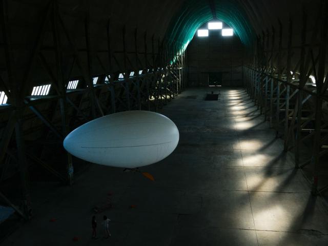 This aerial photograph taken on June 24, 2026 shows an individual airship flying at the Ecausseville's airship hangar, in Ecausseville, western France. (Photo by Lou BENOIST / AFP)