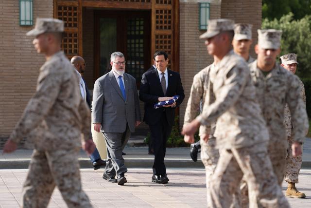 US Secretary of State Marco Rubio holds a folded US flag as he walks with Steven Butler, charge d'affaires ad interim of the US embassy in Kuwait, during a flag raising ceremony at the US embassy during his visit to the Middle East to discuss the interim deal between the U.S. and Iran with Arab Gulf allies, in Kuwait City on June 24, 2026. Rubio arrived in the United Arab Emirates on June 23, and held talks with its leader flying to Kuwait and then Bahrain, where he will attend a Gulf Cooperation Council (GCC) meeting. Rubio's trip is the first by a senior US official to the Middle East since the Iran agreement was signed last week. (Photo by Eric Lee / POOL / AFP)
