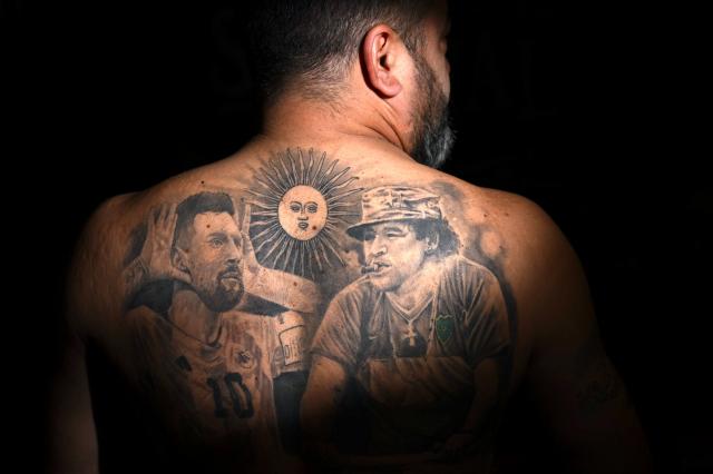 Pablo Homsi, 47, shows his tattoo with images depicting Argentine football star Lionel Messi (L) and late Argentine football legend Diego Maradona in Buenos Aires on June 23, 2026, during the FIFA World Cup 2026. (Photo by Luis ROBAYO / AFP)